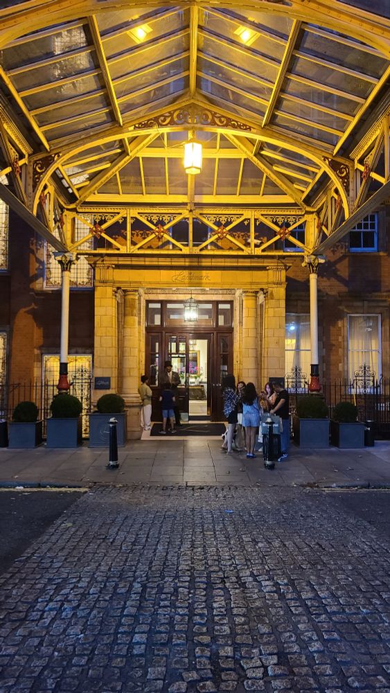 Victorian canopy from station to grand hotel, Marylebone. Doorman in tophat talking with two young boys.