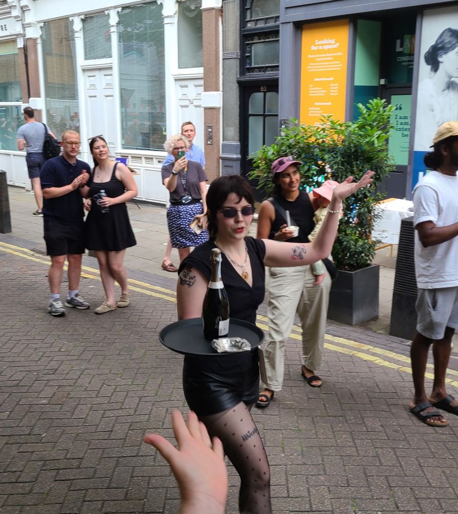 Finishing in style, a waiter waves while carrying her tray to the finish line in the Lsm's Waiters' Race.