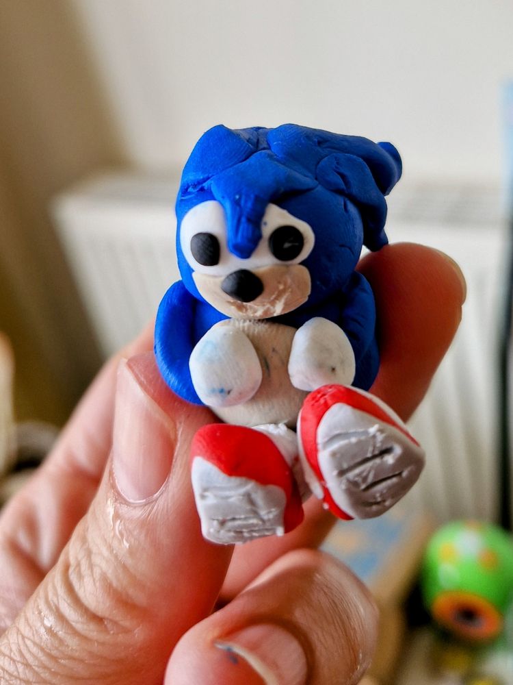 A poorly made clay figurine which looks a little bit like Sonic the Hedgehog and a little bit like the Blue Badger from Ace Attorney.