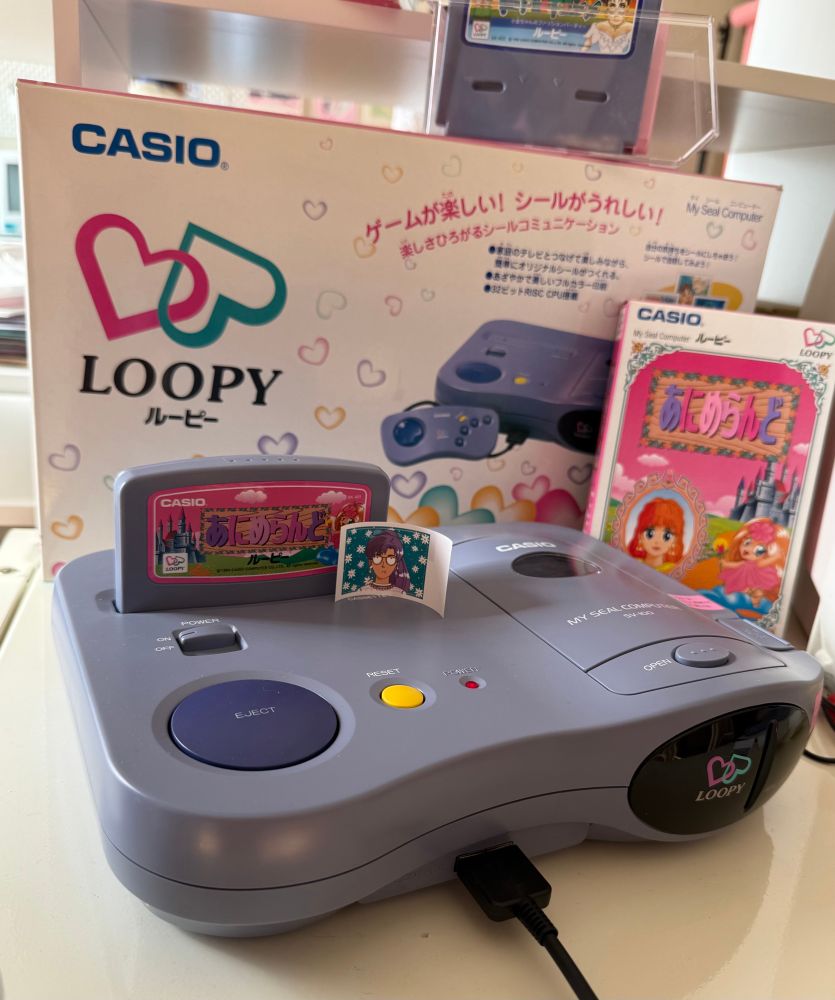 A casio loopy game system! With working sticker printer, and a cute printed sticker on top of it. Retail packaging in the background 