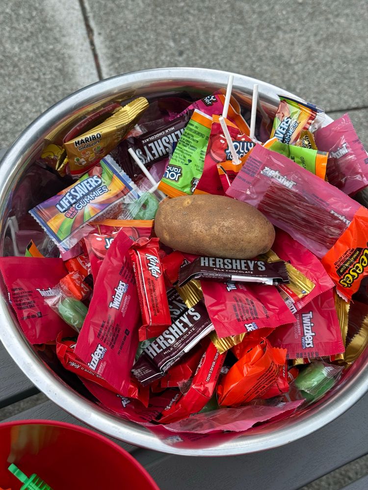 a bowl of halloween candy with a potato in it