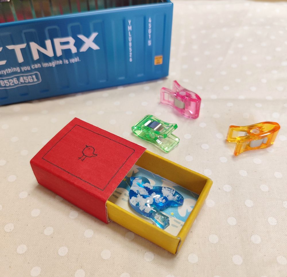 手作りマッチ箱の中にレジンでつくった鳥を閉じ込めたもの