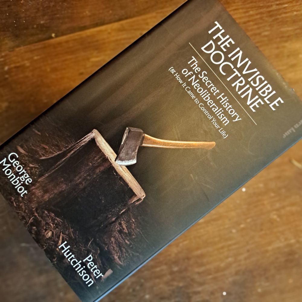 'The Invisible Doctrine' book on wooden table