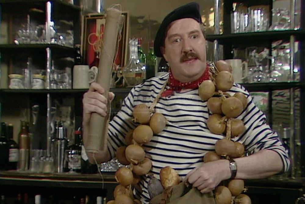 Gordon Kaye - as long-suffering accidental resistance fighter, café owner and unlikely sex object, the one and only René Artois (disguised as his own non-existent twin brother for the purposes of being dead) - wearing a string of onions. Whatever ridiculous set of circumstances necessitated this is best left unexplained - the point in any event was always to get to the next ridiculous situation...