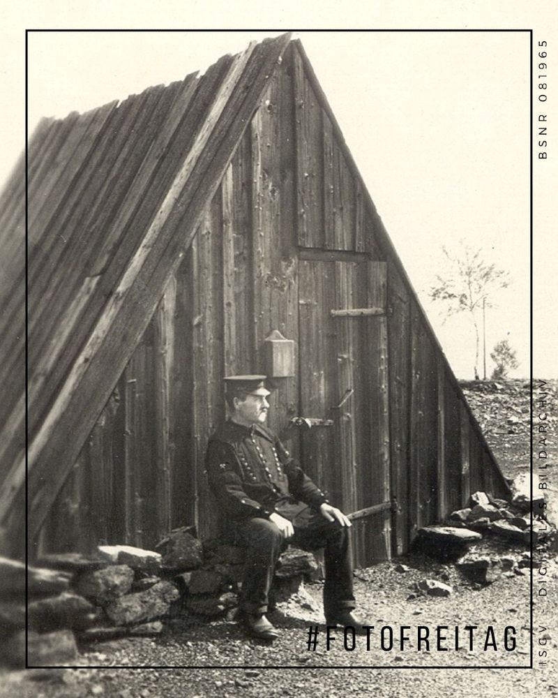 Ein Bergmann sitzt vor dem Eingang zum Abrahamschacht in Freiberg