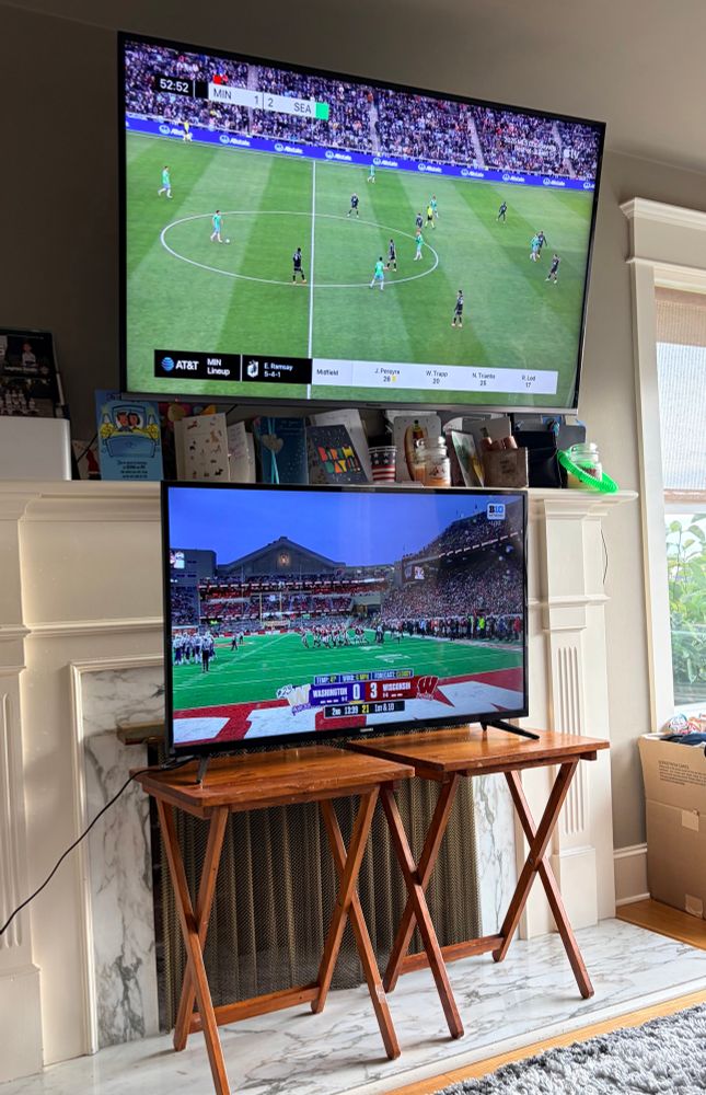 A two tv setup in our living room with Sounders-Minnesota playoff on top and Huskies-Badgers on bottom