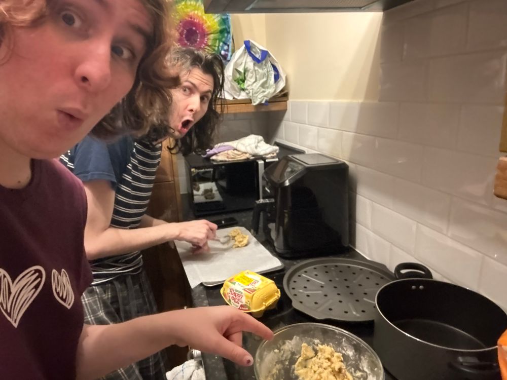 Ruby and Ruth pog while loading cookie dough onto a tray to make cookies 