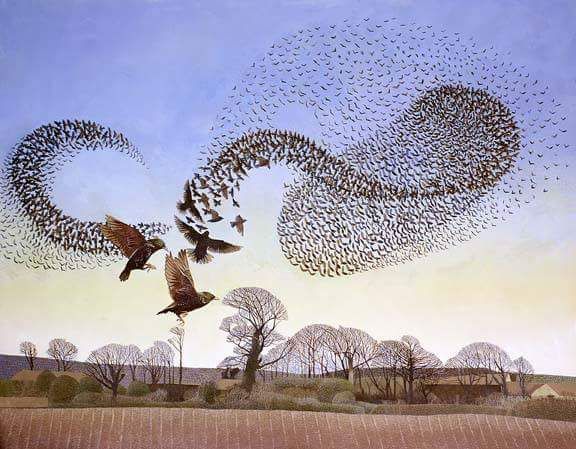 Murmuration of starlings over ploughed field and winter trees