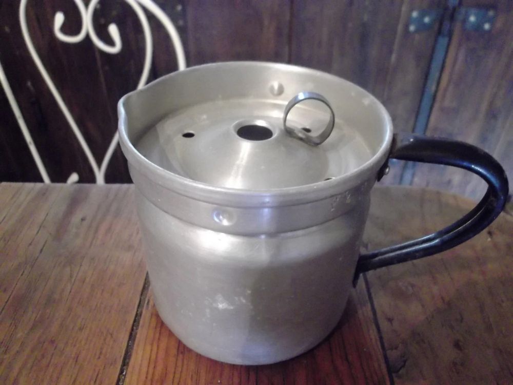 Photo of a vintage milk boiler. Kinda looks like a blocky metal teapot with a weird lid.