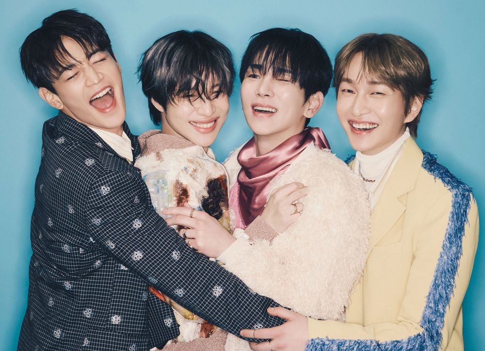 Photo of the members of K-pop band Shinee in a group hug with big smiles. Minho, Taemin, Key, and Onew.