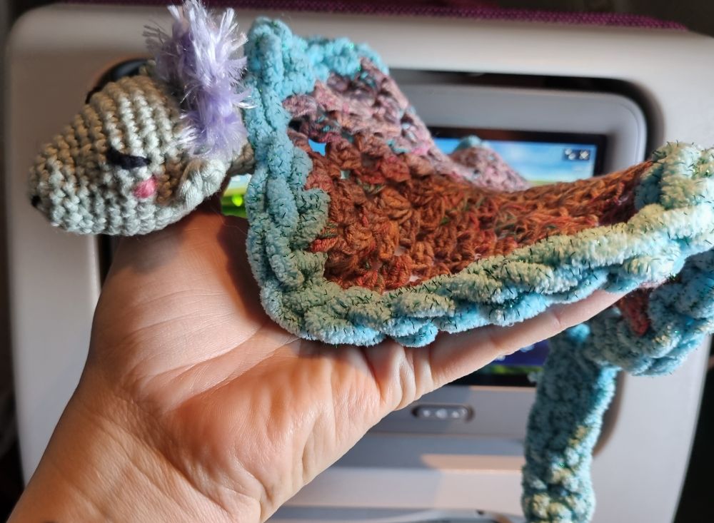 Another photo of the same crochet dragon. We can easily see the light mauve crest on top of its head. 