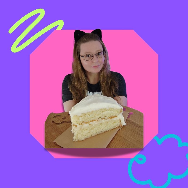 Me, a blonde woman, holding up a piece of cake on a cutting board. I'm inside a pink shape frame, inside a purple square PFP. 