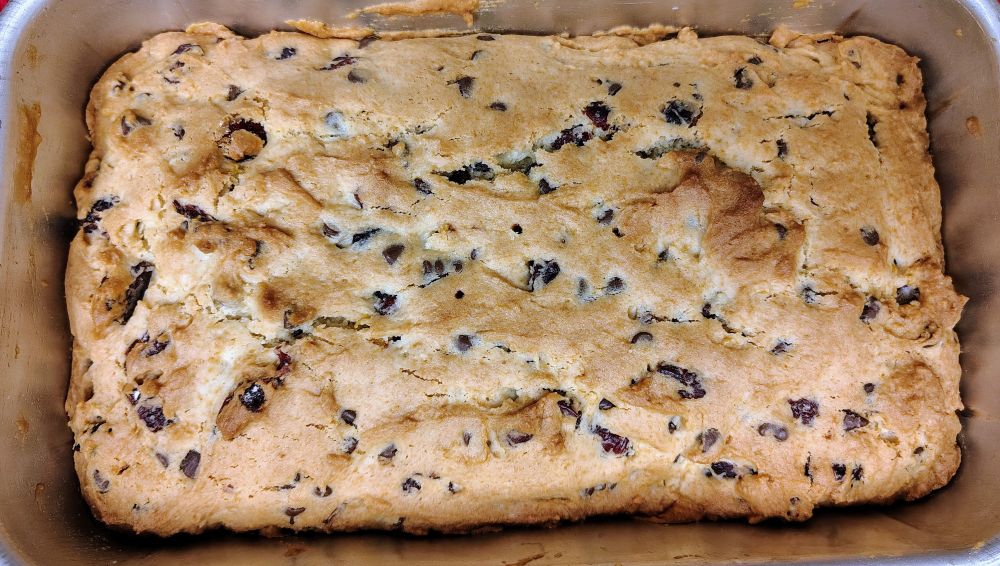 A loaf of Orange Cranberry Chocolate Chip Bread in a loaf pan