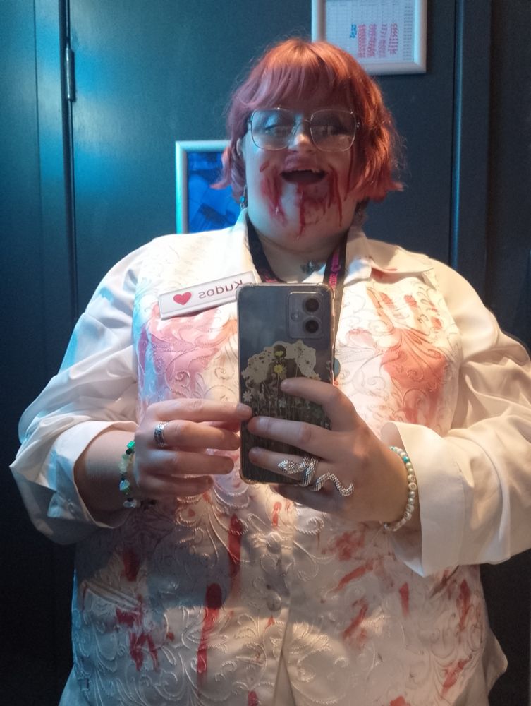 Liz dressed as vampire Lucius. She is wearing a bloody white waist coat and has blood on her face.