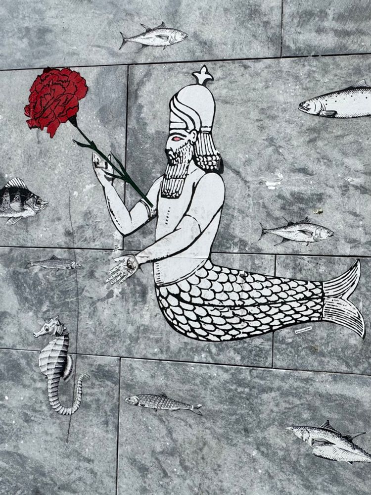Wheat paste of a Phoenician (?) merman among fish on a stone wall