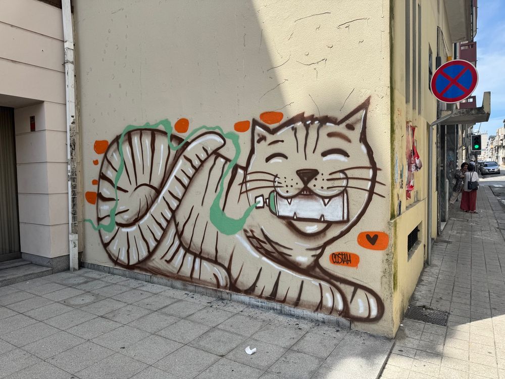 A tag illustration of a graffiti cat with a spray can in its mouth 