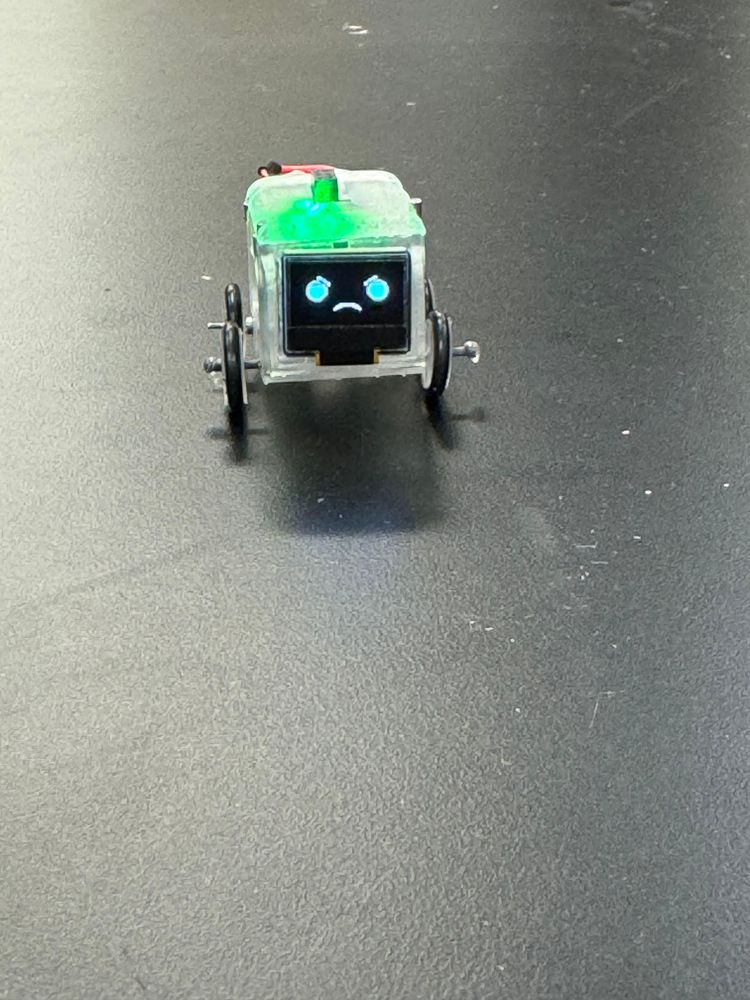 Mini robot displaying a neutral face.
