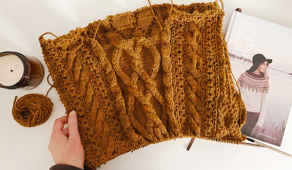 A squishy cabled sweater in progress in a golden, butterscotch color. Looks like it would taste like caramel.