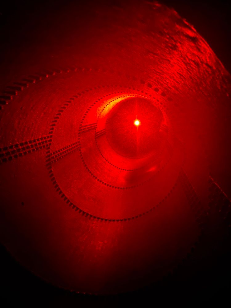 Small red light at the end of a large industrial pipe.