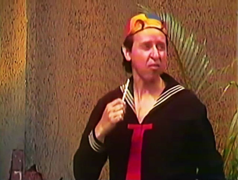 a man in a sailor outfit is holding a toothpick