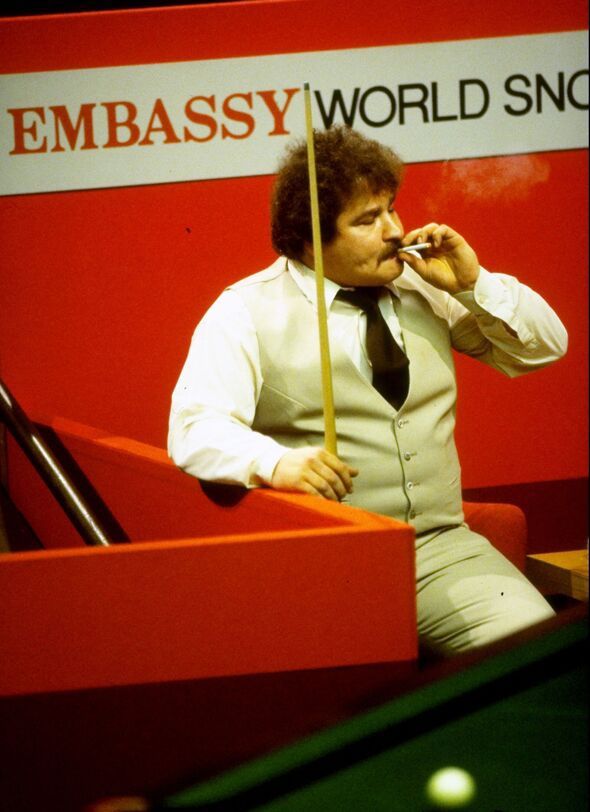 Bill Werbeniuk enjoying a cigarette while waiting for his shot at the Embassy World Snooker Championship. 