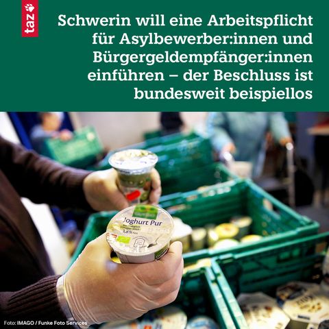An einer Essensausgabe hält jemand mit Handschuhen Joghurt in die Kamera. Dahinter grüne Boxen mit Essen gefüllt. 