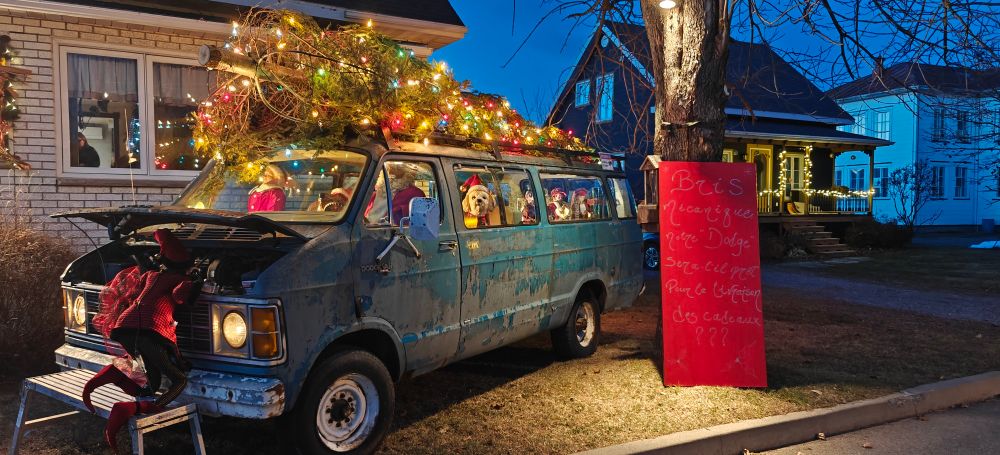 Cette décoration de Noël est très originale. Dans cette vieille camionette en panne avec un sapin de Noël illuminé sur le toit se trouvent le Père et la Mère Noël avec un chien et des lutins. Un lutin est penché sous le capot ouvert et semble réparer la camionnette pour pouvoir terminer la distribution des cadeaux. 