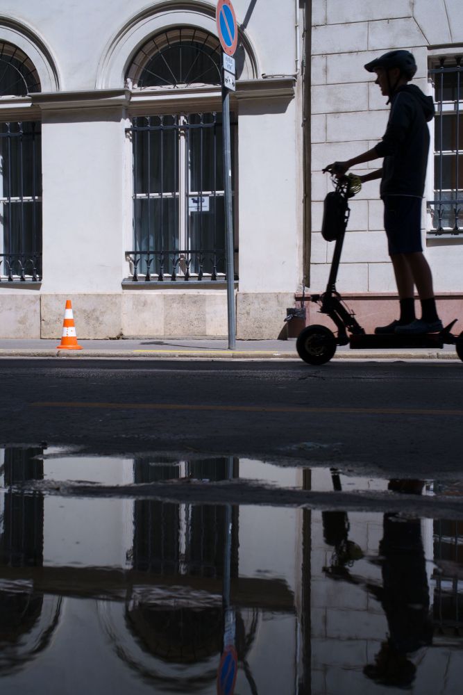 Reflection shot of a person on a scooter