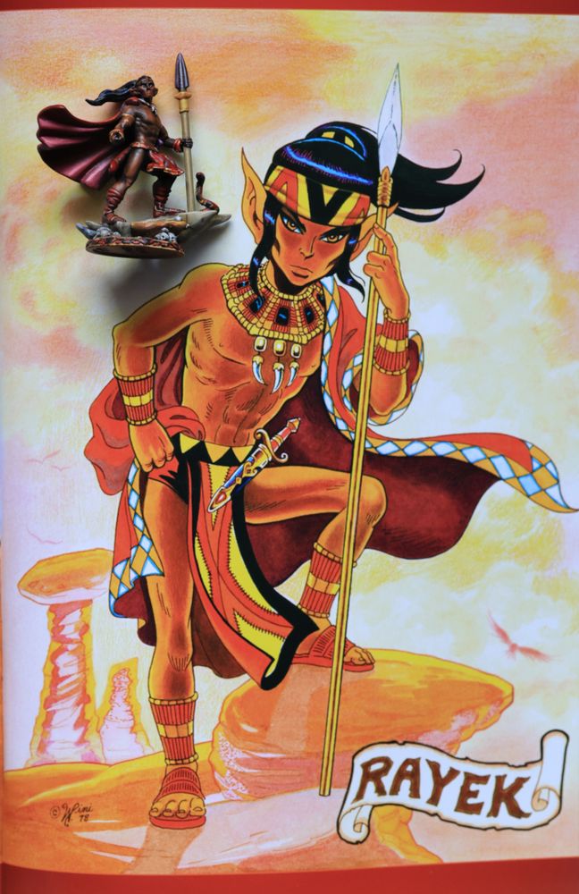 A painted 3d-printed figurine of Elfquest's Rayek, in comparison with the original painting by Wendy Pini from ~ 1978. Rayek, the dark-skinned elf of the desert village "Sorrow's End" is standing on the rocks, resting on his hunting-spear, his cape blowing in the wind. This was the inspiration for the 3d-printed figurine.