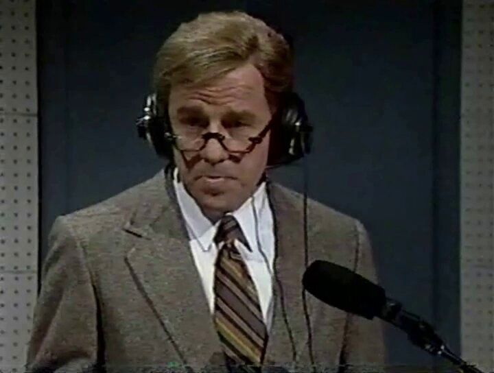 Phil Hartman playing Charton Heston wearing headphones 
