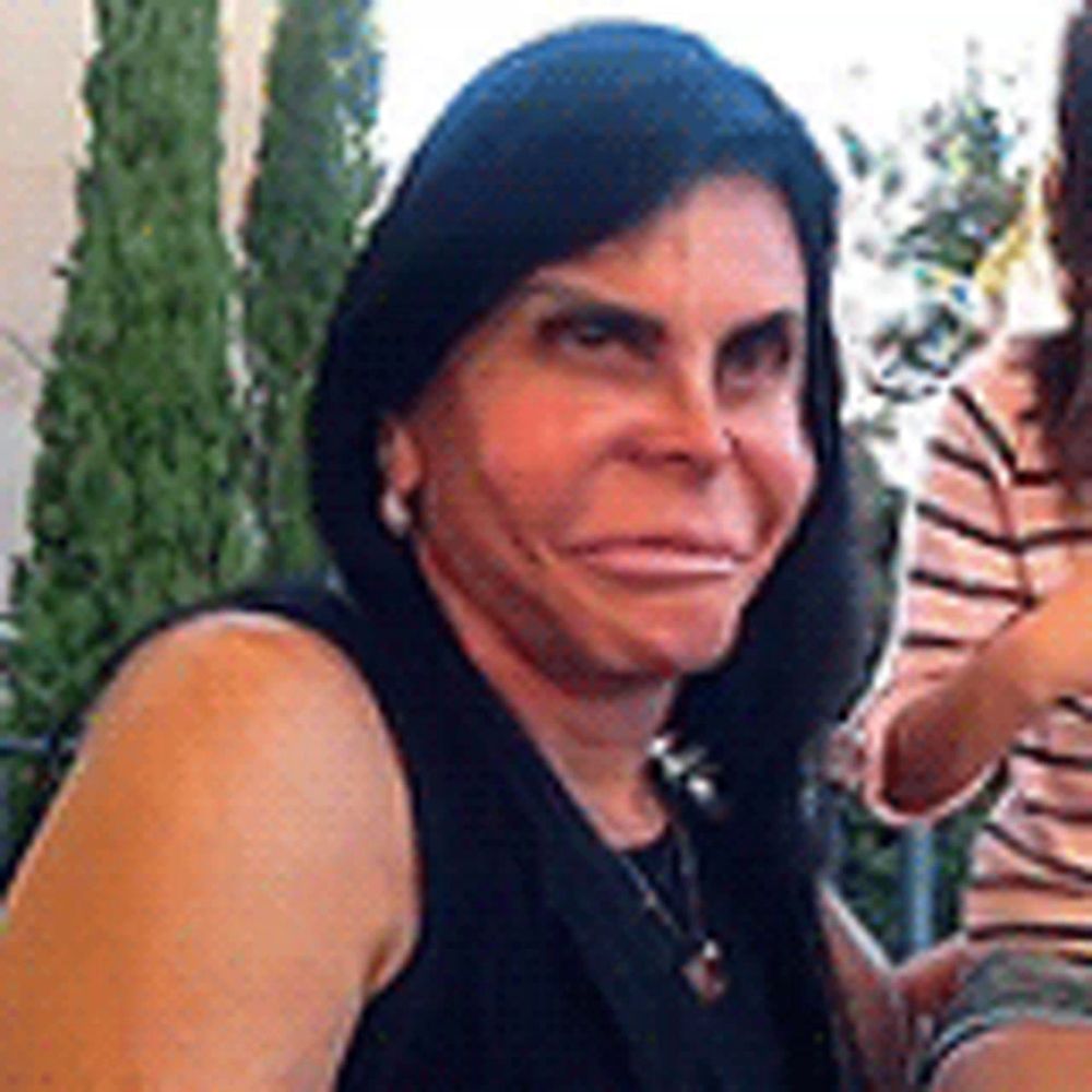 a woman with long black hair is sitting at a table with a woman .