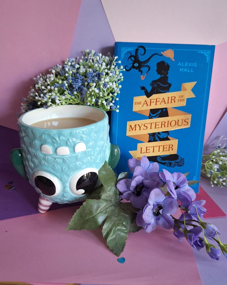 The Book The Affair of the Mysterious Letter by Alexis Hall next to a monster shaped tea mug and surrounded by flowers.

Description:
Upon returning to the city of Khelathra-Ven after five years fighting a war in another universe, Captain John Wyndham finds himself looking for somewhere to live, and expediency forces him to take lodgings at 221b Martyrs Walk. His new housemate is Miss Shaharazad Haas, a consulting sorceress of mercurial temperament and dark reputation. When Miss Haas is enlisted to solve a case of blackmail against one of her former lovers, Captain Wyndham finds himself drawn into a mystery.