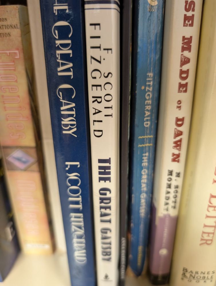 picture of a bookshelf with three editions of The Great Gatsby