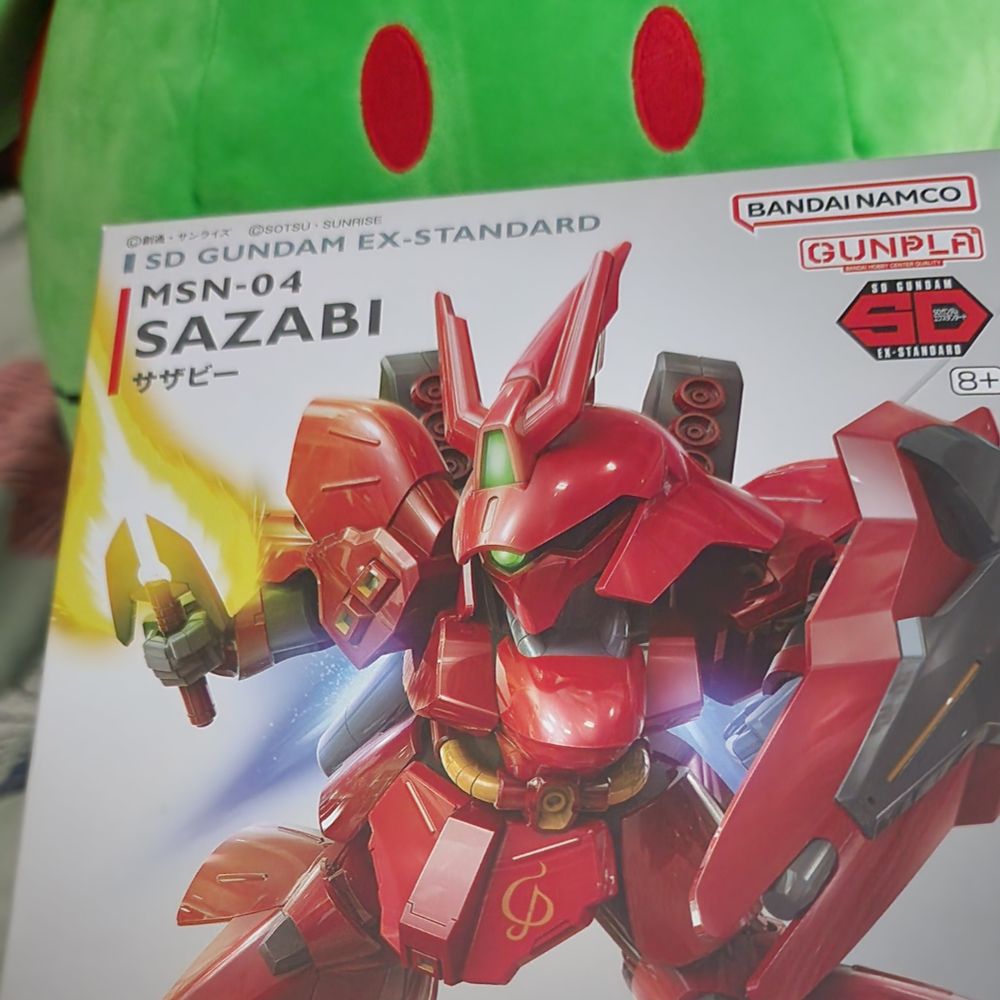 SD Sazabi box with big plush Haro's eyes looming in the background.