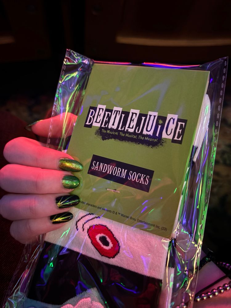 beetlejuice sandworm sock merch with 2 bright green nails and 2 black nails with green stripes