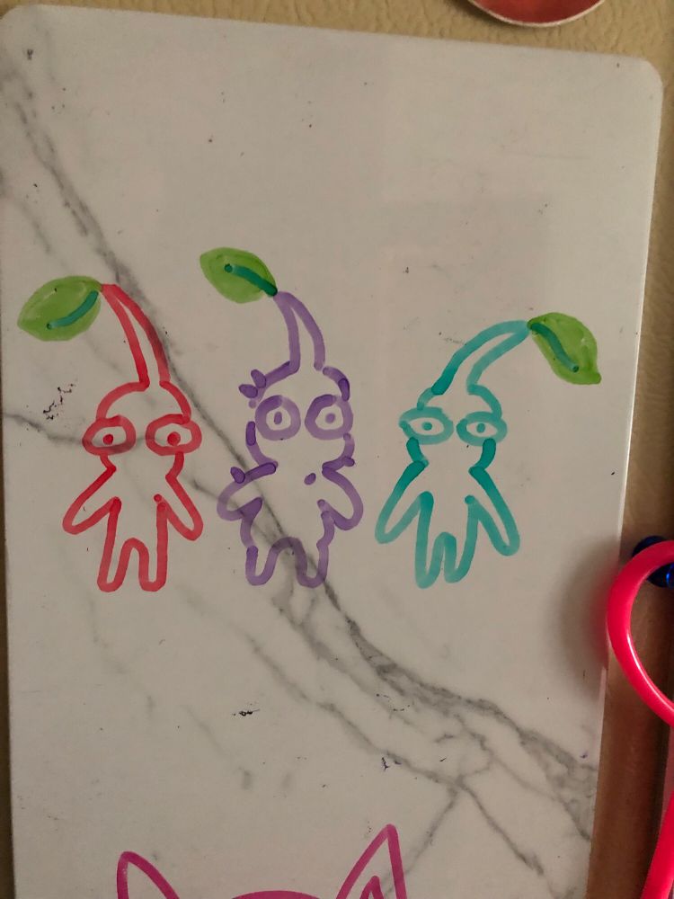 Dry erase drawing of a red, a purple, and a blue Pikmin.