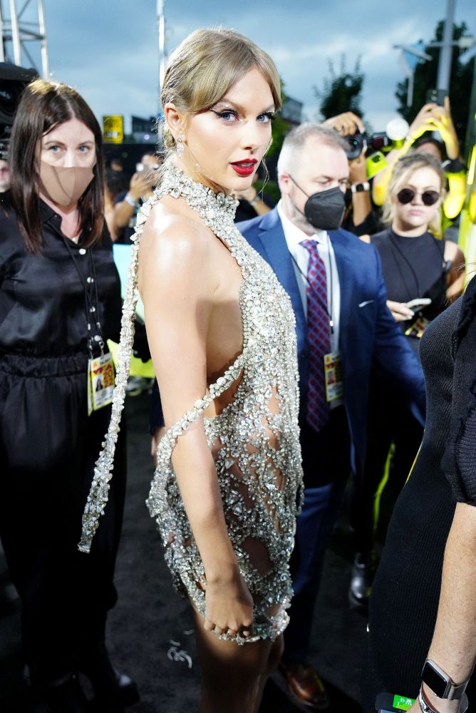 Taylor on the MTV black carpet in her bejeweled dress, as though she was draped in diamond in necklaces/chains: from her right side, 3/4 profile