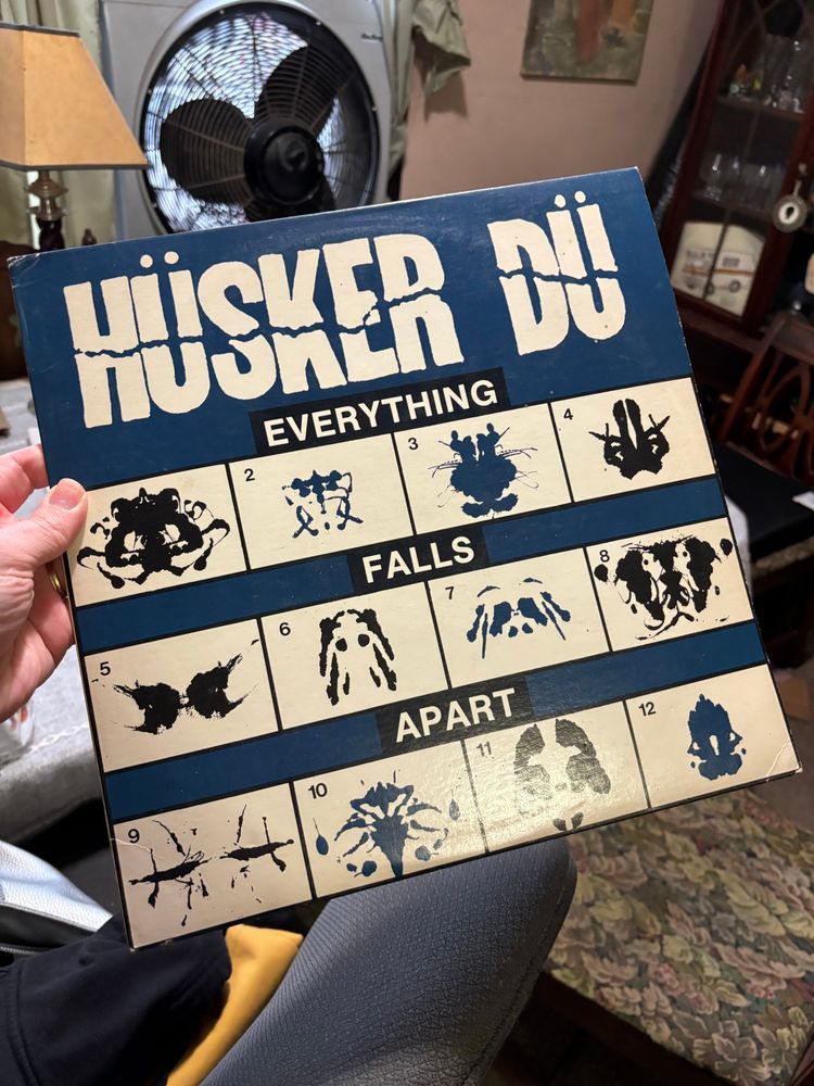 the cover of the lp everything falls apart by hüsker dü, featuring twelve numbered ink blots on a blue background.