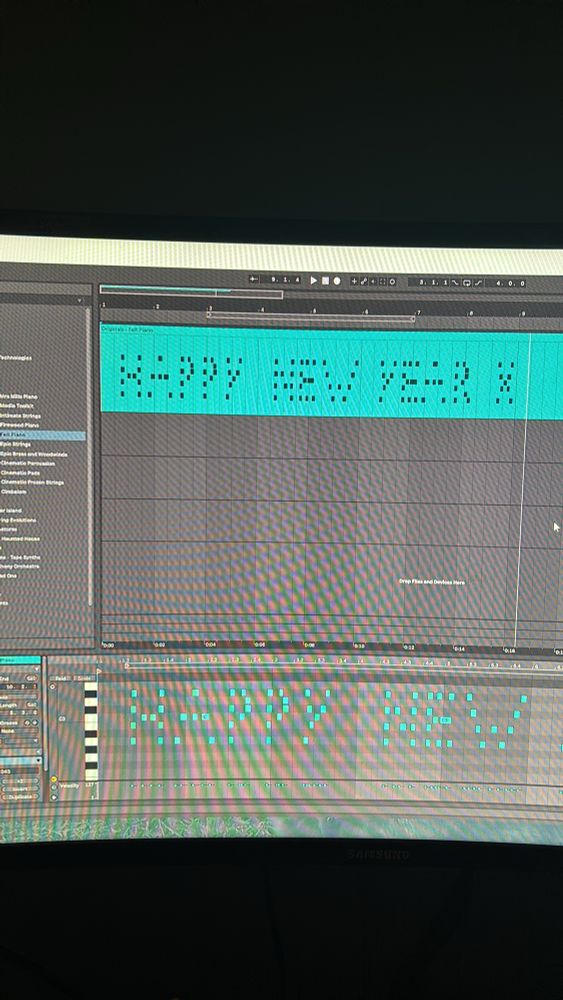 A photo of a screen showing production software with MIDI notes spelling Happy New Year x