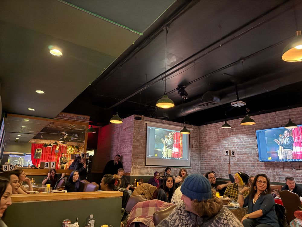 #VanSlam audience fills a restaurant. Slam scorecards are up in the air.