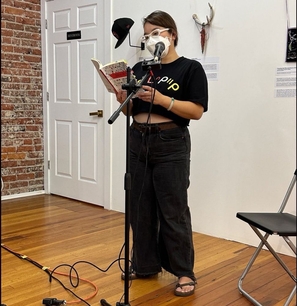 Ellen Chang-Richardson up at the mic, reading from their book BLOOD BELIES