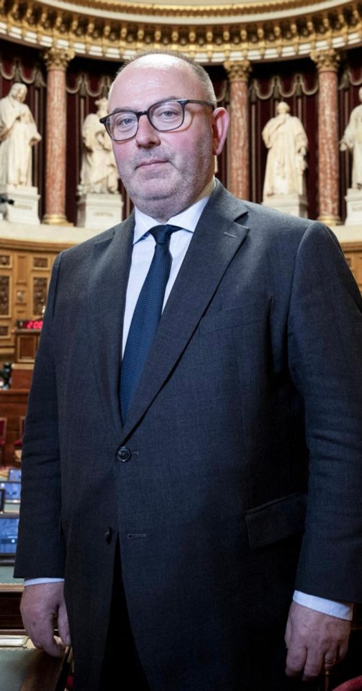 Photo du sénateur Laurent Duplomb, figé et souriant, l’air satisfait dans la salle du sénat. 
