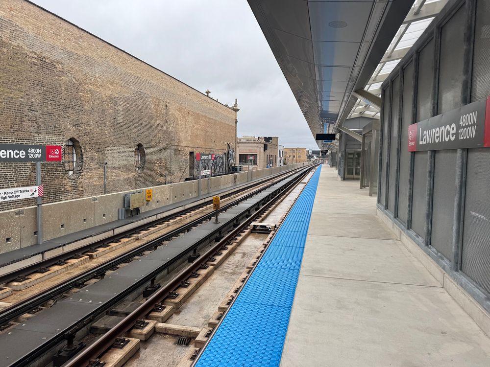 The wall of the Aragon Ballroom stands to the left of the Red Line tracks, with the new Lawrence station platform to the left.