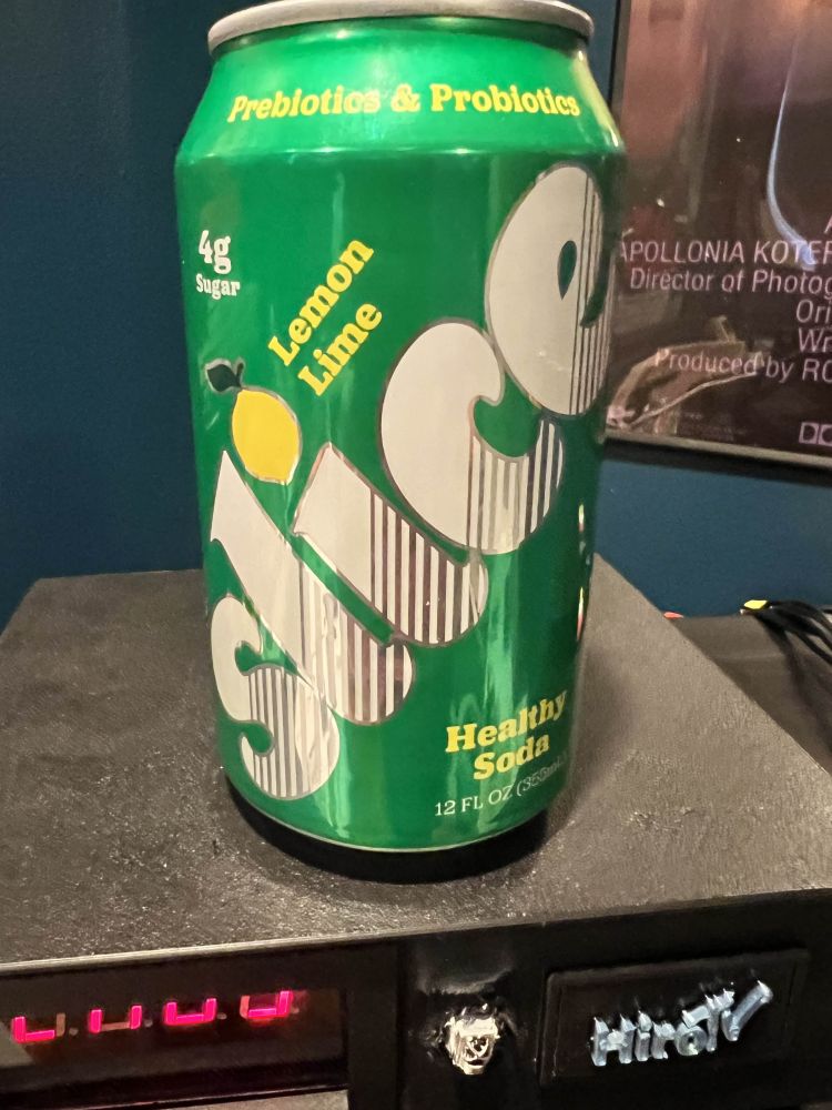 A green can of Slice soda sitting on a cable box.