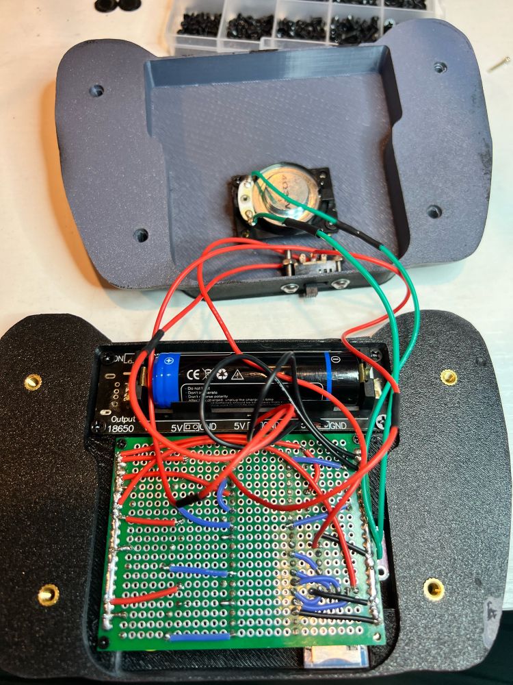 A 3D printed case opened to show the dice rollers internal parts.