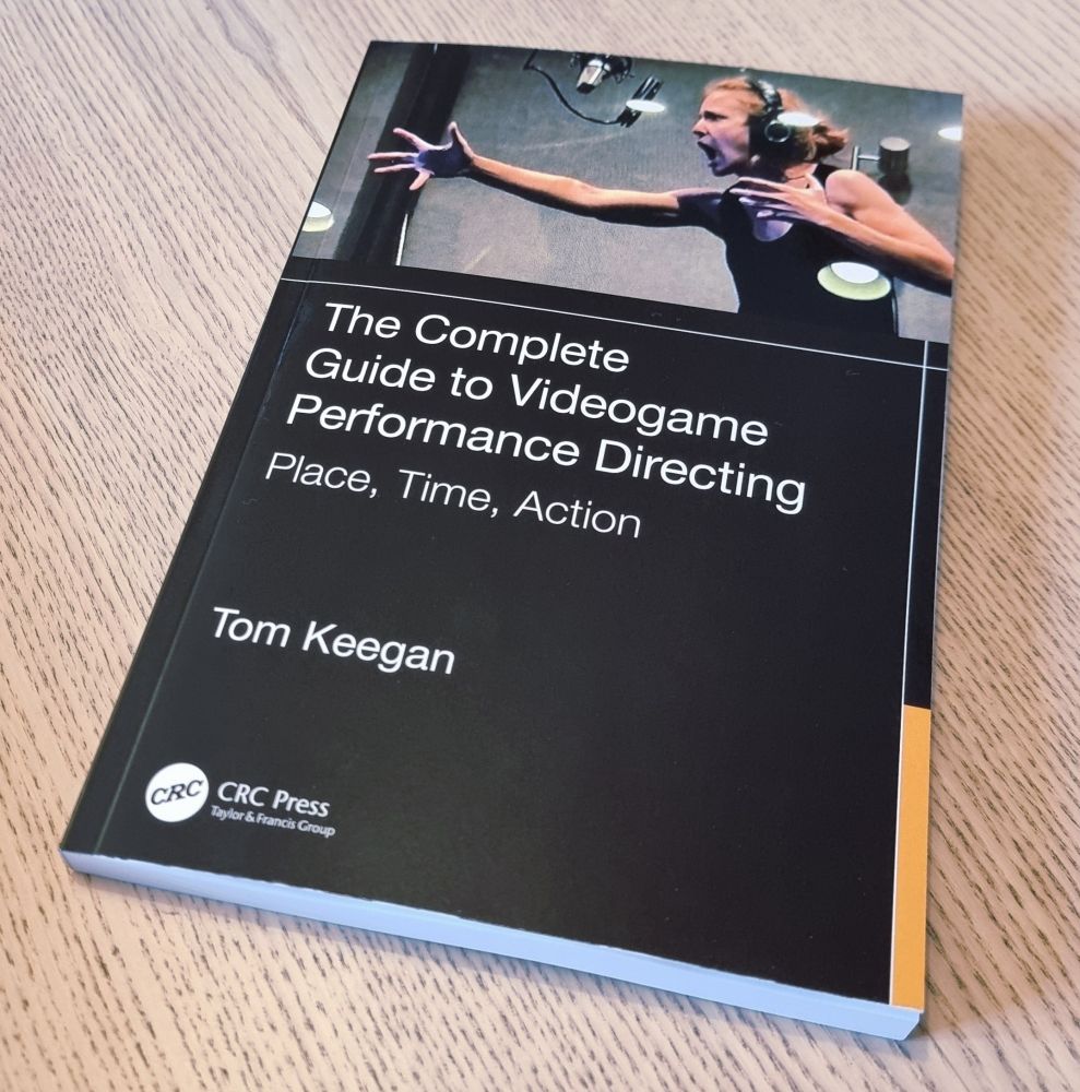 The book "The complete guide to videogame performance directing" sits on a table.