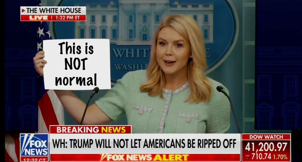 Press Sec holding sheet of paper that has been doctored to say "This is NOT normal"