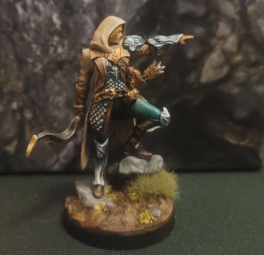 A painted miniature gaming figure of a female hunter with a bow.
