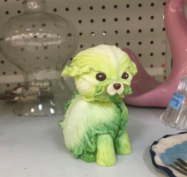 A weird lettuce dog sculpture on a shelf 
