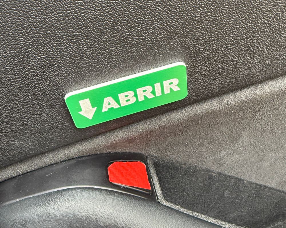 Botón para abrir la puerta en un coche Tesla con un cartelito que indica que se trata del botón para abrir la puerta 